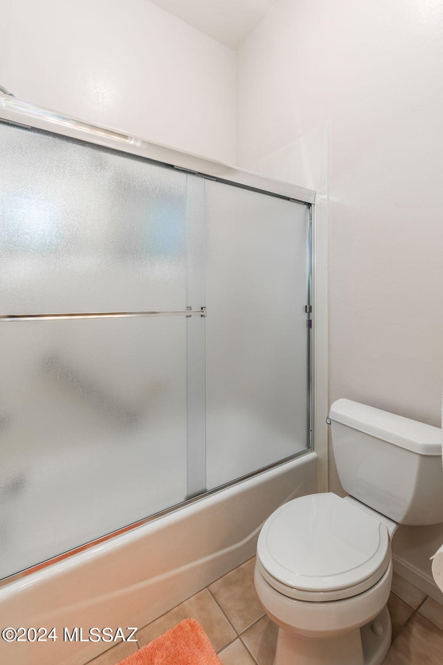 bathroom with toilet, tile patterned floors, and enclosed tub / shower combo