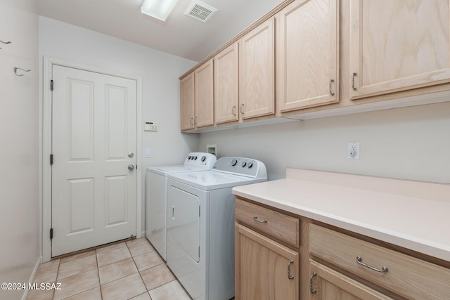 washroom featuring washer and clothes dryer, light tile patterned floors, and cabinets