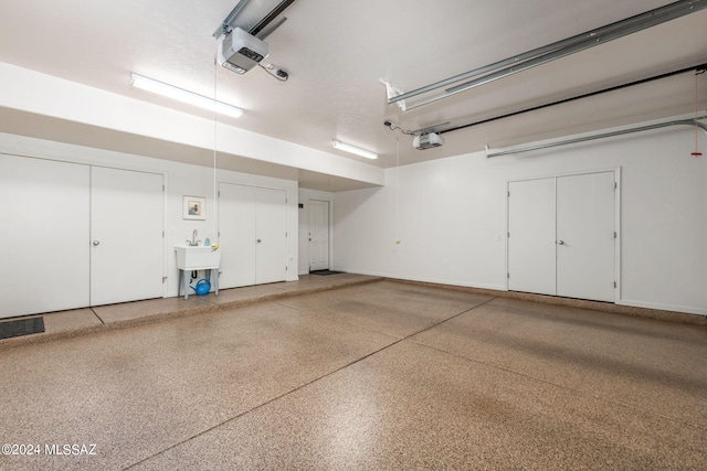 garage featuring sink and a garage door opener