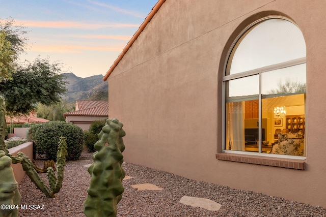 property exterior at dusk with a mountain view