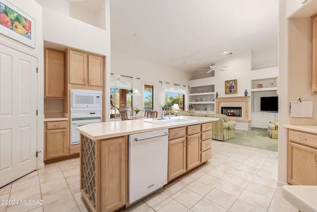 kitchen with light brown cabinetry, white appliances, sink, ceiling fan, and pendant lighting