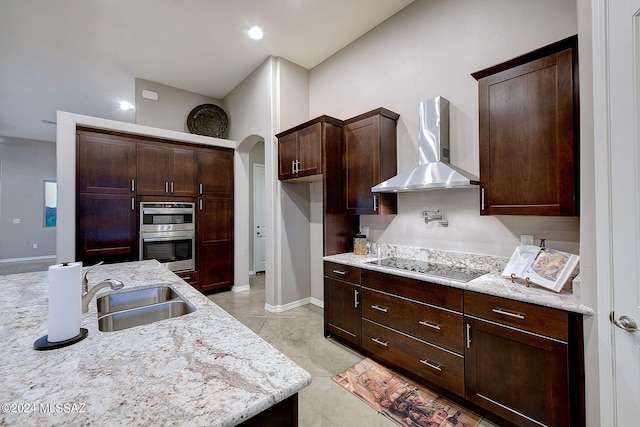 kitchen featuring black electric stovetop, light stone counters, sink, and wall chimney exhaust hood