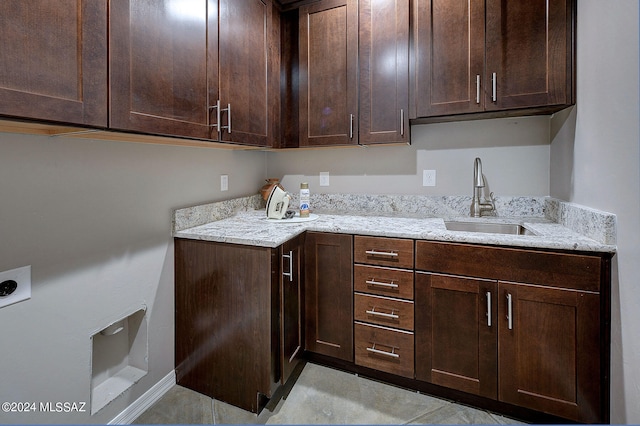 clothes washing area featuring light tile patterned floors, cabinets, sink, and hookup for an electric dryer