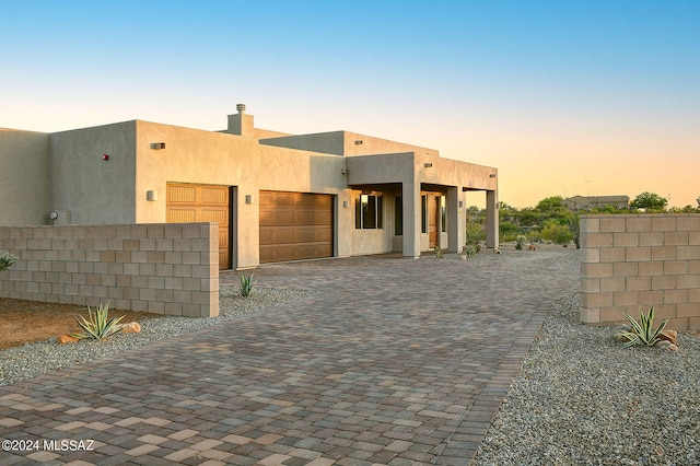 pueblo revival-style home with a garage