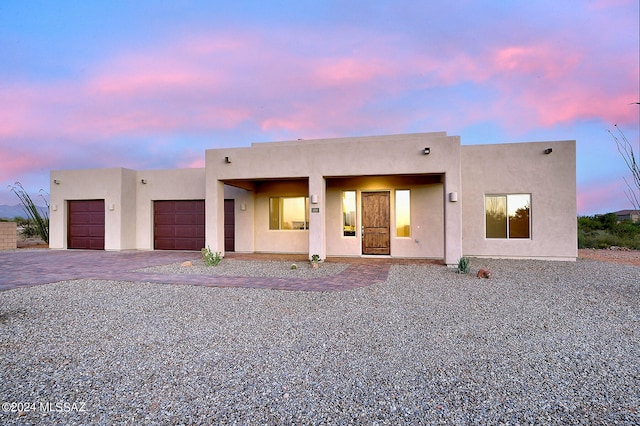 pueblo-style house featuring a garage