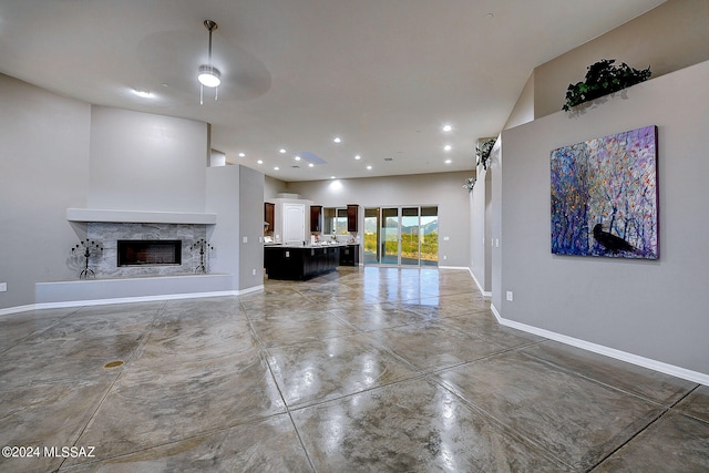 unfurnished living room featuring concrete flooring and ceiling fan