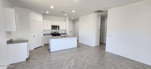 kitchen featuring white cabinetry, sink, stainless steel appliances, and light stone countertops