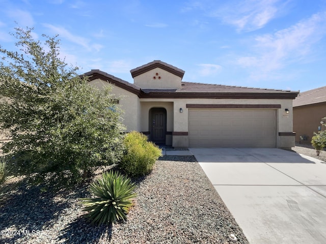 view of front of property featuring driveway, an attached garage, and stucco siding