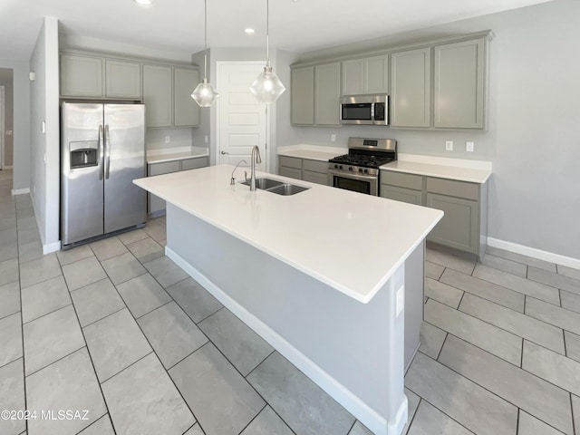 kitchen featuring appliances with stainless steel finishes, gray cabinets, and a sink