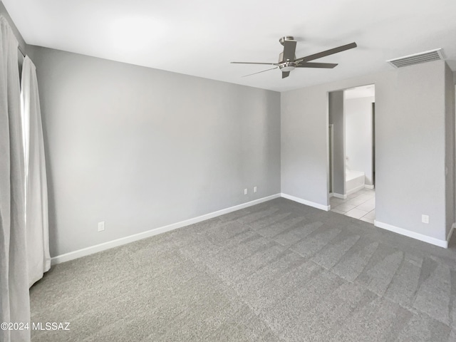 unfurnished bedroom with ceiling fan, carpet flooring, visible vents, baseboards, and ensuite bath