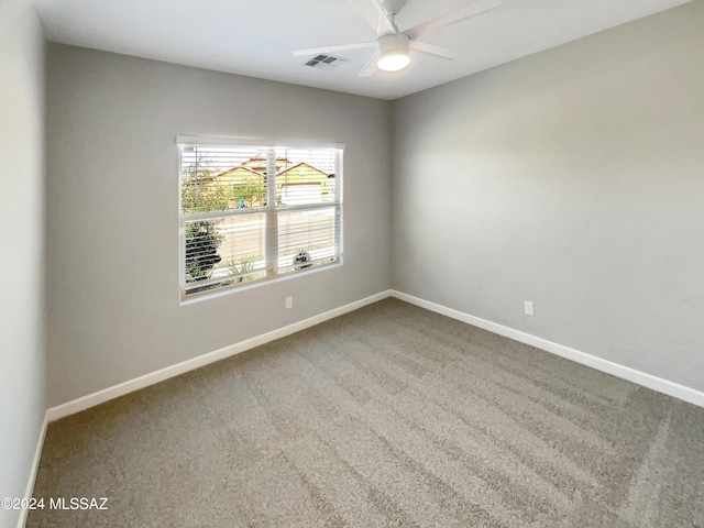 carpeted empty room featuring visible vents, ceiling fan, and baseboards