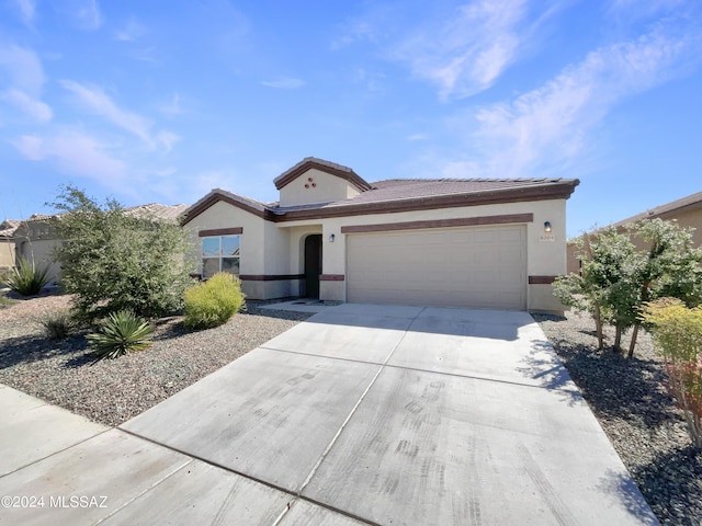 view of front of house with concrete driveway, an attached garage, and stucco siding