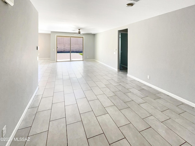 spare room featuring a ceiling fan and baseboards