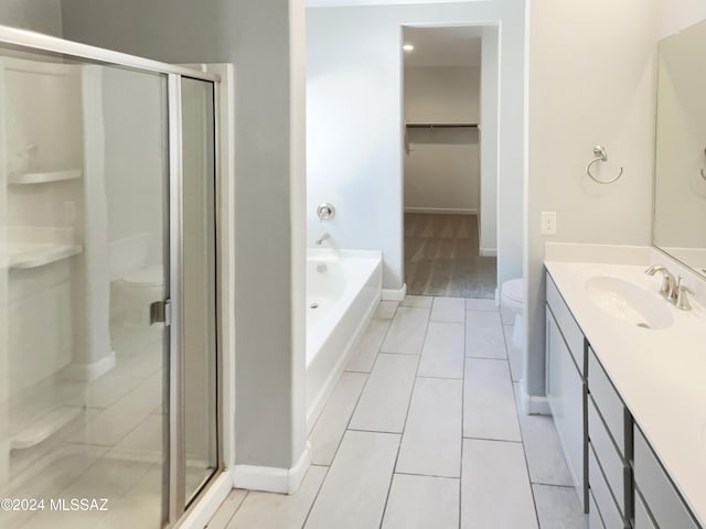 bathroom featuring a garden tub, vanity, a shower stall, and toilet