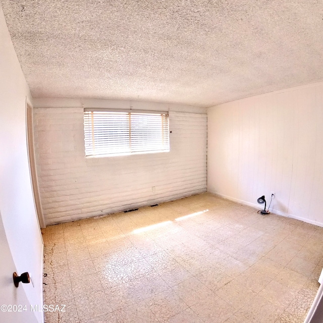 unfurnished room with a textured ceiling