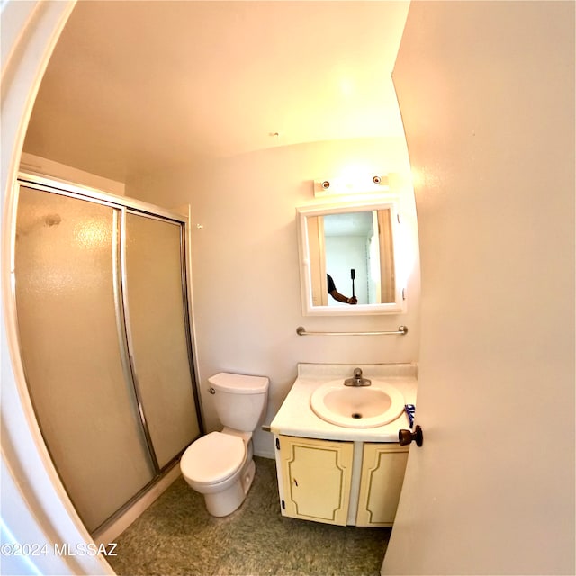 bathroom featuring toilet, vanity, and an enclosed shower