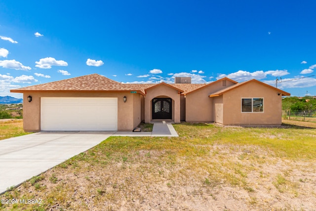 view of front of property with a front yard and a garage