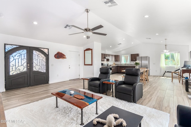 living room with light wood-type flooring, ceiling fan, lofted ceiling, and french doors