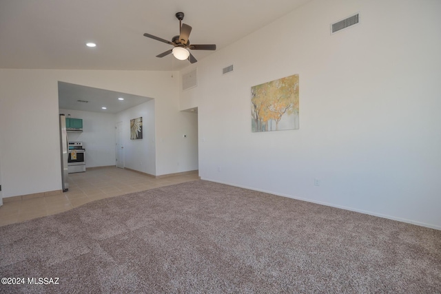 unfurnished living room with ceiling fan, lofted ceiling, and light carpet