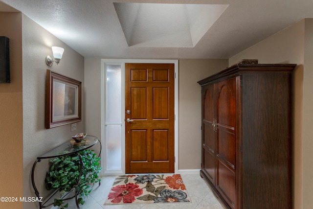 entrance foyer featuring a textured ceiling and light tile patterned floors