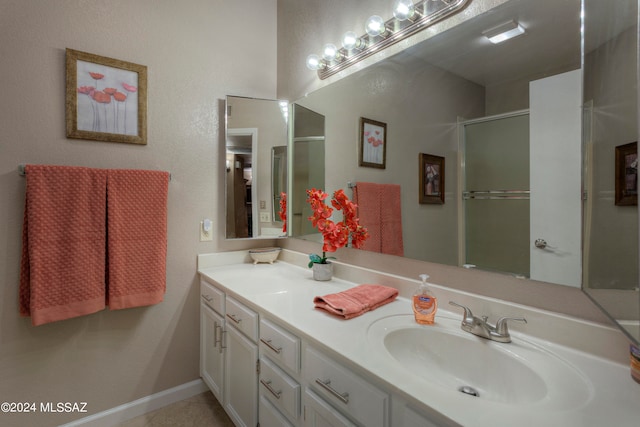 bathroom with a shower with door, tile patterned flooring, and vanity