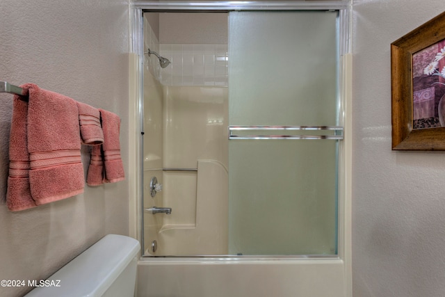 bathroom featuring toilet and enclosed tub / shower combo