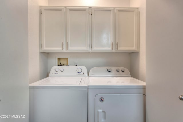 laundry room with independent washer and dryer and cabinets