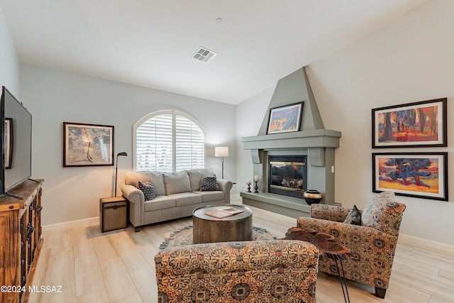 living room featuring a large fireplace and light hardwood / wood-style flooring