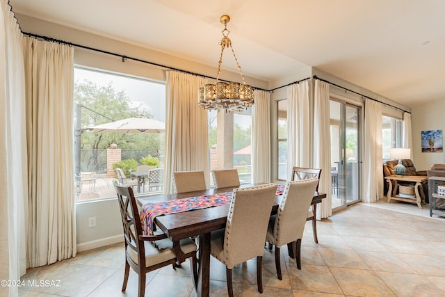 tiled dining room with a chandelier