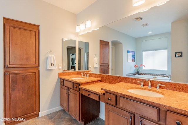 bathroom featuring vanity, tile patterned floors, and a tub