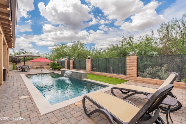 view of swimming pool with pool water feature and a patio