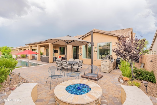 back of house with a fenced in pool, a patio area, and an outdoor living space with a fire pit