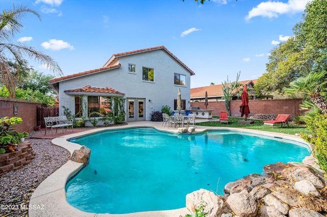 view of swimming pool featuring french doors and a patio area