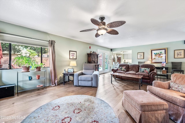 living room with light wood-type flooring, a healthy amount of sunlight, and ceiling fan