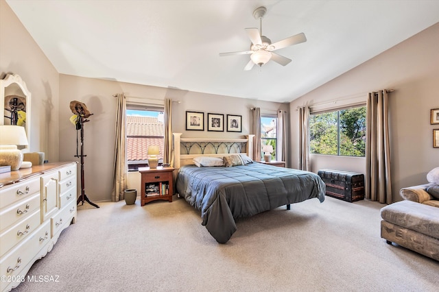 carpeted bedroom with multiple windows, vaulted ceiling, and ceiling fan