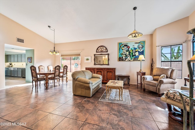 living room with high vaulted ceiling, a wealth of natural light, and a chandelier