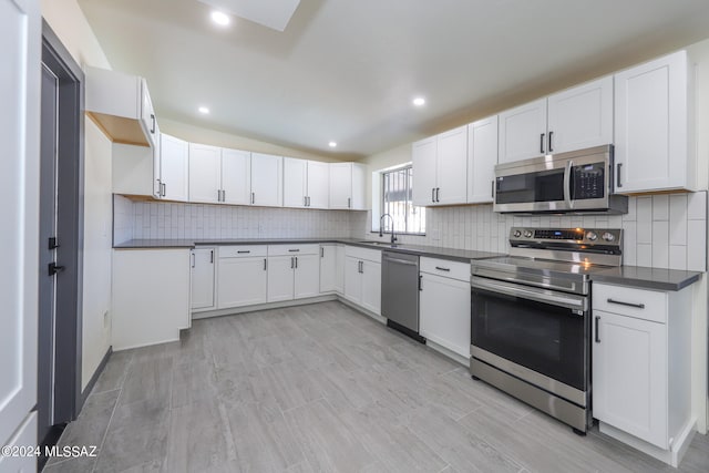 kitchen with stainless steel appliances, white cabinetry, and sink