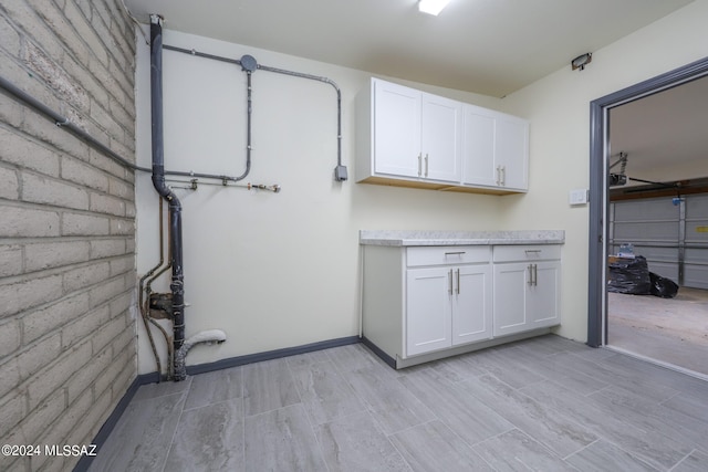 washroom with brick wall and light hardwood / wood-style floors