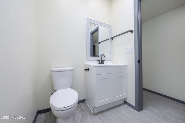 bathroom featuring vanity, toilet, and hardwood / wood-style floors