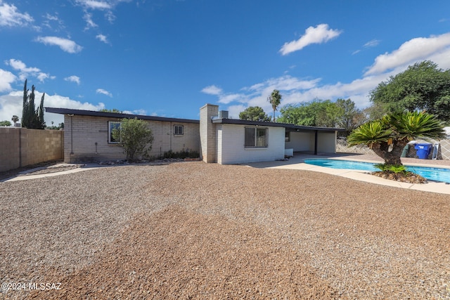 view of front of house with a fenced in pool and a patio area