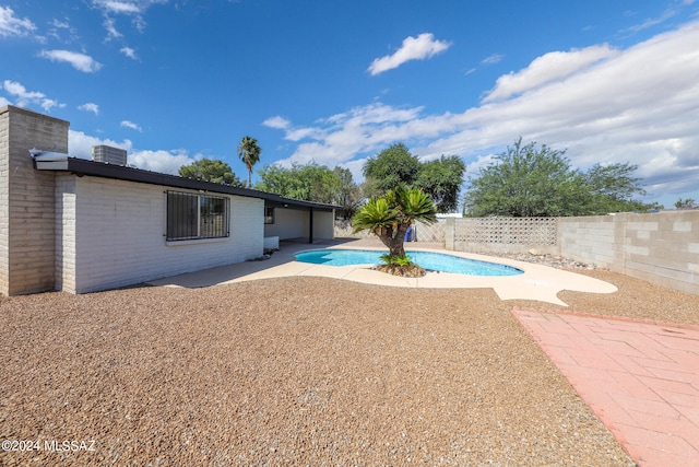 exterior space featuring a fenced in pool and a patio