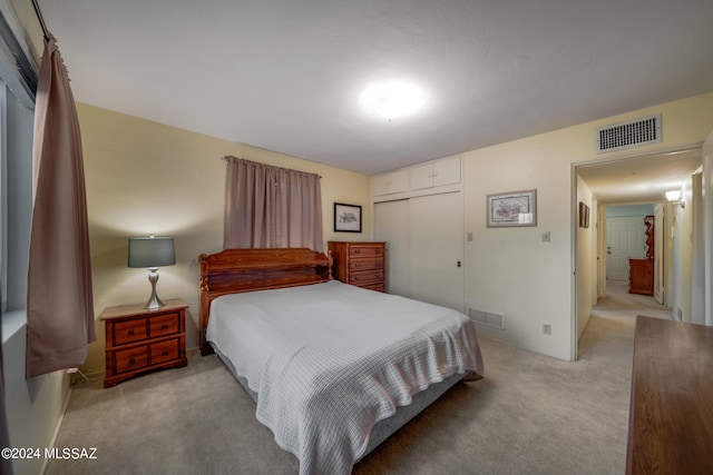 bedroom featuring light carpet and a closet