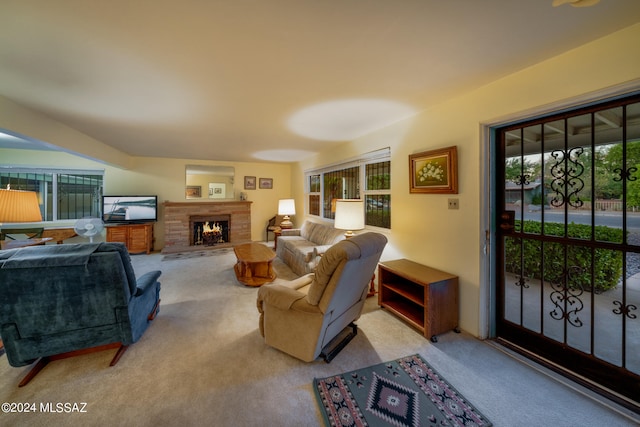 carpeted living room featuring a stone fireplace