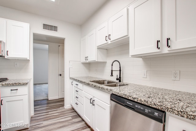 kitchen with dishwasher, light hardwood / wood-style flooring, light stone counters, and sink