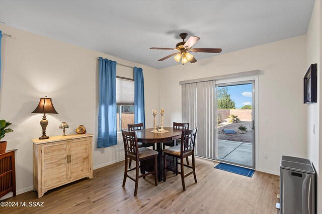 dining area with light wood-type flooring and ceiling fan