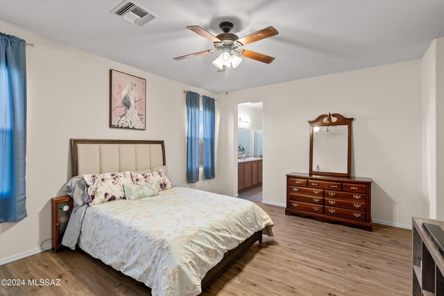 bedroom with ceiling fan, light hardwood / wood-style floors, and ensuite bathroom