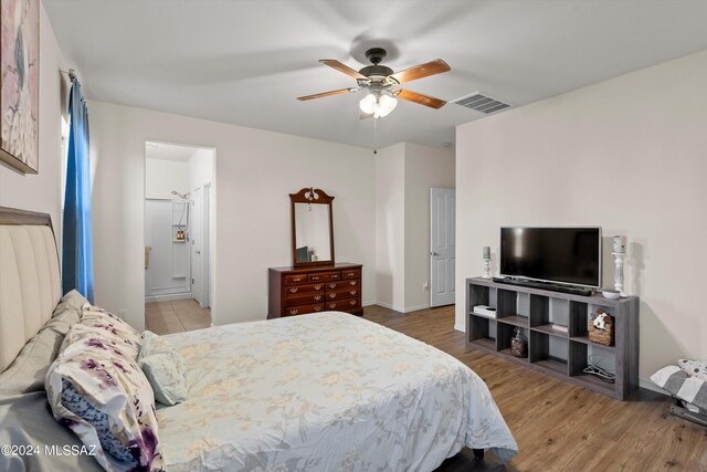 bedroom with ceiling fan, hardwood / wood-style floors, and ensuite bathroom