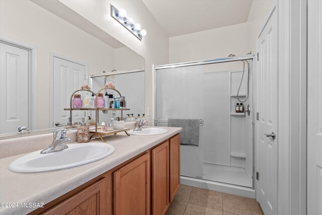 bathroom featuring vanity, a shower with shower door, and tile patterned flooring