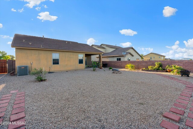 rear view of property with cooling unit and a patio area