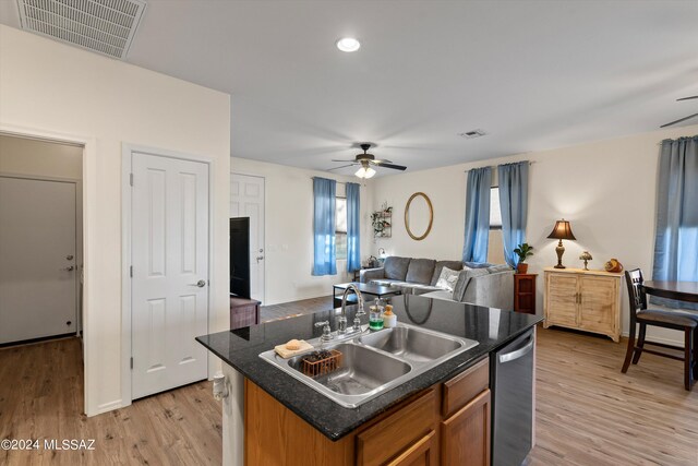 kitchen with a kitchen island with sink, light wood-type flooring, dishwasher, sink, and ceiling fan